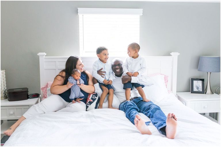 Candid photo of family on bed at Pittsburgh newborn session 