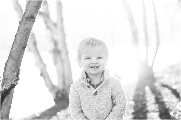 Little boy smiling among birch trees on Pittsburgh's North Shore Riverwalk