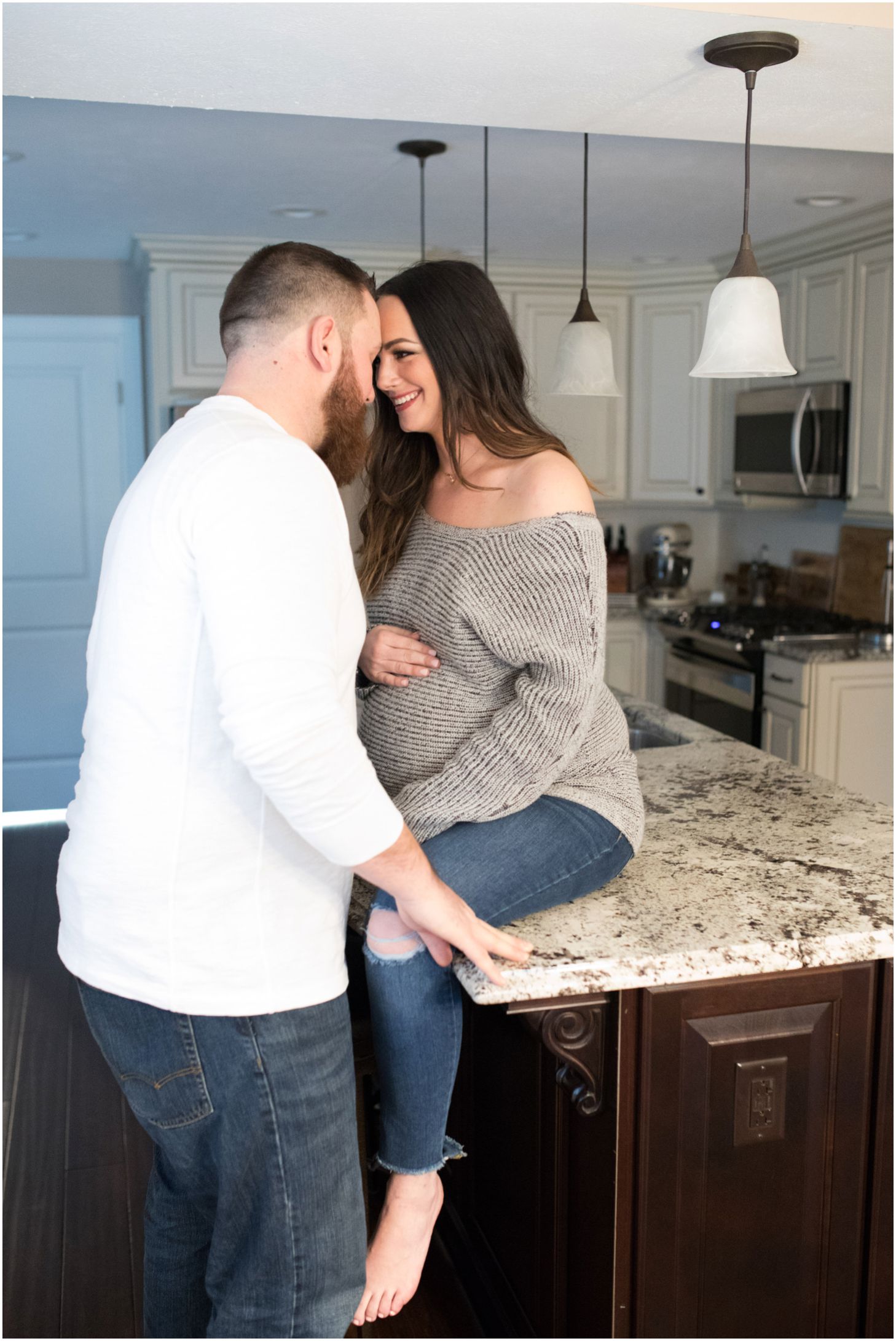 mom and dad snuggle up together in the kitchen | maternity session